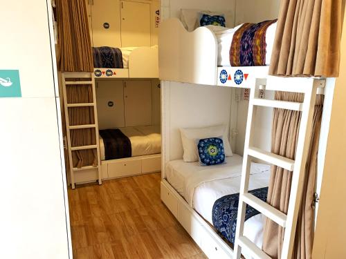 a small room with bunk beds and a ladder at Ozora Tiying Tutul Hostel Canggu in Canggu