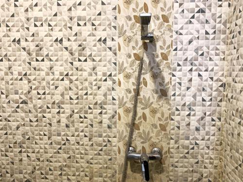 a shower in a bathroom with a tiled wall at Ozora Tiying Tutul Hostel Canggu in Canggu