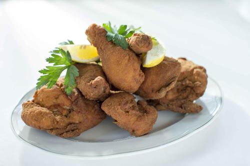 a plate of fried food with lemon slices and parsley at Hotel Staribacher Südsteiermark in Leibnitz