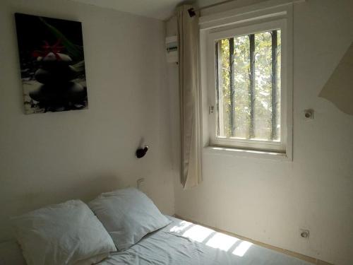 1 dormitorio con cama y ventana en Single storey 40m² bordering pine forest and spa en Noves