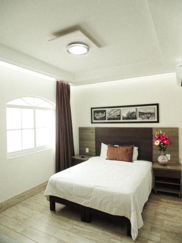 a bedroom with a large bed and a window at Hotel River Poliforum in León