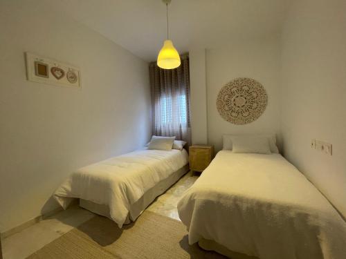 ルセナにあるEl Callejón del Molinoのベッドルーム1室(ベッド2台、ペンダントライト付)