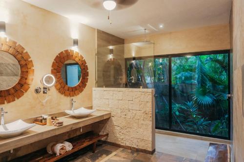 baño con 2 lavabos y ventana grande en Aldea Coba An Escape Boutique Experience, en Cobá