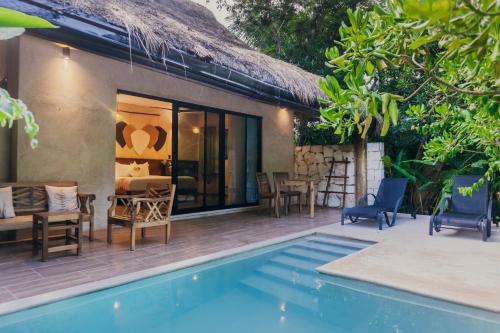 a villa with a swimming pool and a house at Aldea Coba An Escape Boutique Experience in Coba