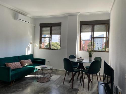 sala de estar con sofá verde y mesa en Apartamento turístico La Joya, en Huelva