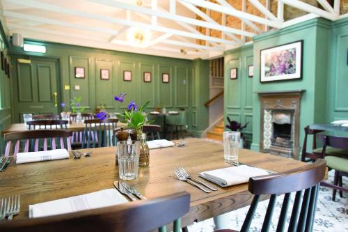 a dining room with a wooden table and a fireplace at Charming Kintbury Cottage in Kintbury