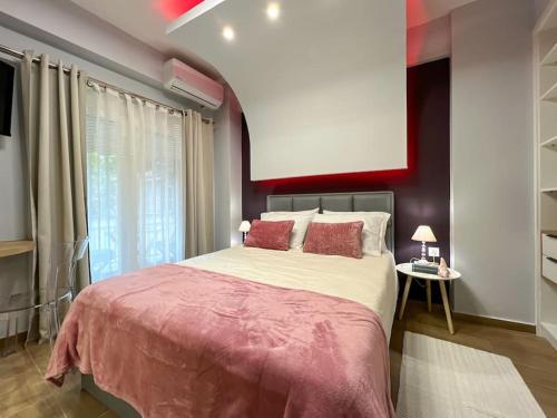 ein Schlafzimmer mit einem großen Bett mit einer rosa Decke in der Unterkunft Purple studio in Thessaloniki