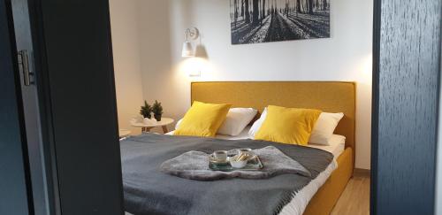 um quarto com uma cama com almofadas amarelas e um cobertor em Golte SkiCenter Apartment em Mozirje