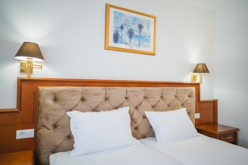 a bedroom with a bed with white sheets and two pillows at Pansion Lipa in Blato