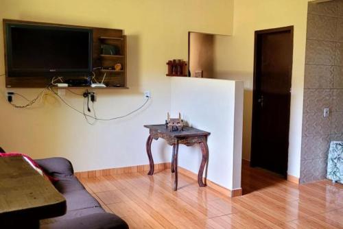 a living room with a table in front of a refrigerator at Borges House in Imbituba