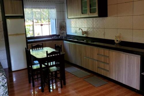 una cocina con mesa y algunas sillas. en Borges House, en Imbituba