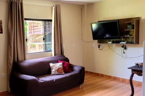 een woonkamer met een bank en een flatscreen-tv bij Borges House in Imbituba