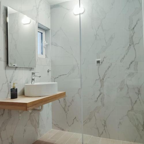 uma casa de banho branca com um lavatório e um espelho em Dream Apartment Ioannina em Ioannina