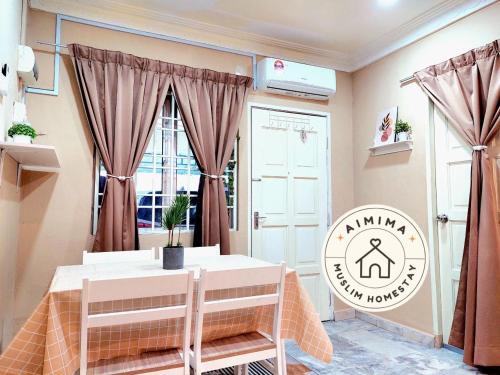 Aimima Muslim Homestay @ Lost World Of Tambun. في Kampong Batu Lapan: غرفة طعام مع طاولة ونافذة