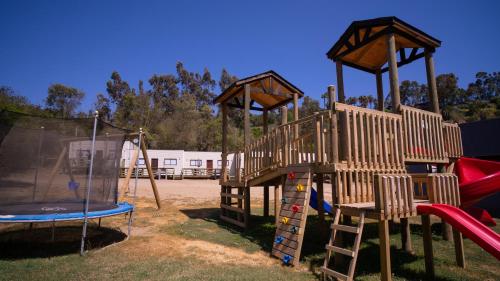un parque infantil con tobogán y columpio en cabañas laguna de zapallar maitencillo, en Zapallar