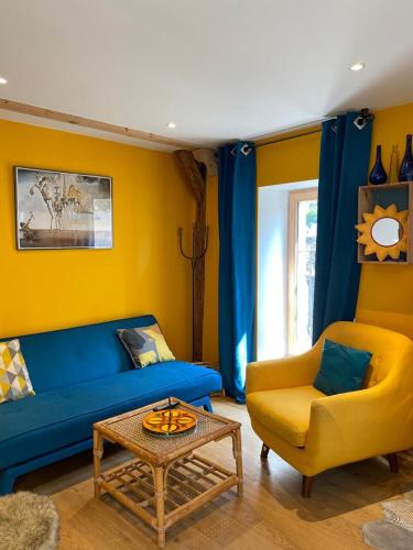 a living room with a blue couch and a yellow chair at Au Cheval Blanc - appartements et chambres d'hôtes in Albertville
