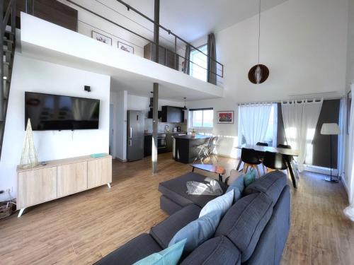 Il comprend un grand salon avec un canapé et une télévision. dans l'établissement Azur Arts Lanzarote Lofts, à Tinajo