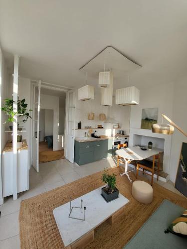 un salon avec une table et une cuisine dans l'établissement Appartement La verrerie, terrasse et jardinet, à Cognac