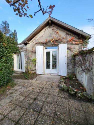 - un petit bâtiment avec une porte blanche dans l'établissement Appartement La verrerie, terrasse et jardinet, à Cognac