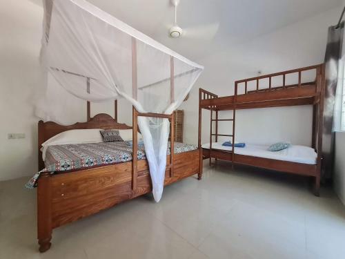 a bedroom with two bunk beds in a room at Ladha ya Zanzibar Boutique Guesthouse in Jambiani