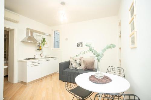 a living room with a white table and a couch at Modena Centro Junior Suite in Modena