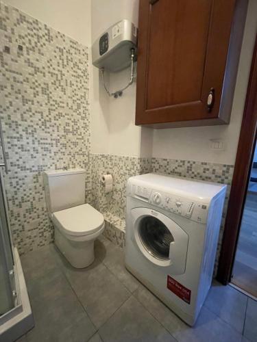 a bathroom with a washing machine and a toilet at Cami s holidays home in Catania