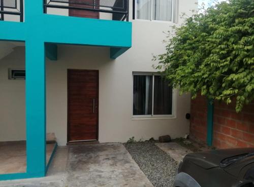 a house with a door and a tree in front of it at Lo de Sil in Santa Teresita