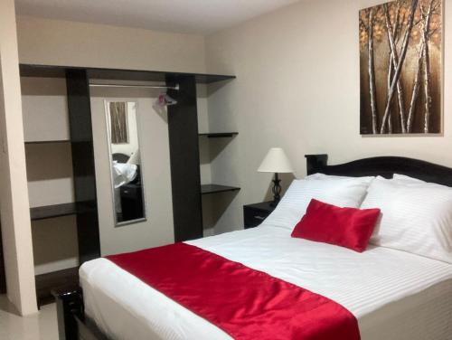 a bedroom with a large bed with a red blanket at Hospedaje Ana Lu 2, Only 10 minutes from airport in Alajuela City