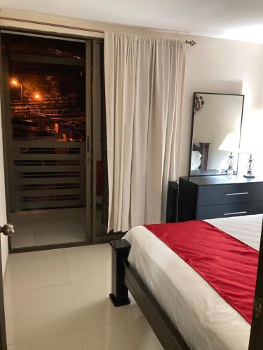 a bedroom with a bed and a large window at Hospedaje Ana Lu 2, Only 10 minutes from airport in Alajuela City