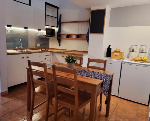 cocina con mesa de madera y sillas en La Chalana, en Porís de Abona