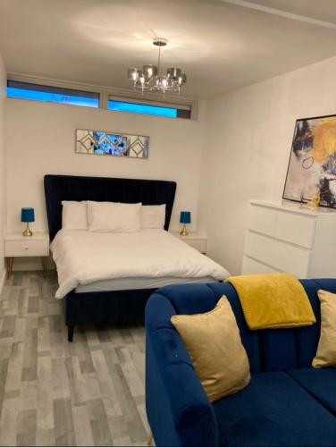 1 dormitorio con 1 cama y 1 sofá azul en City of London, en Londres