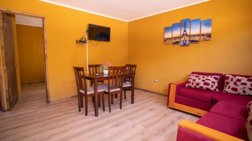 a living room with a table and a red couch at cabañas laguna de zapallar maitencillo in Zapallar