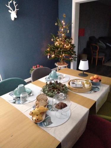 a table with food and a christmas tree in a room at Chambre double in Boersch