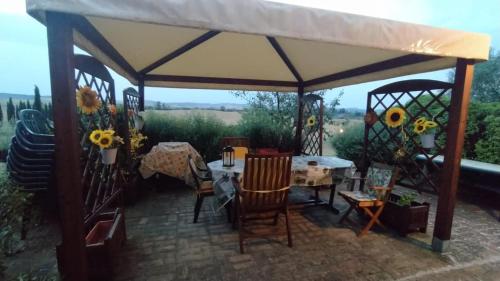 a gazebo with a table and chairs under it at Country House Girasole Crete Senesi Vakantie Huis in Asciano