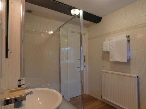 a bathroom with a glass shower and a sink at Brook Marston Farm Hotel in Sutton Coldfield