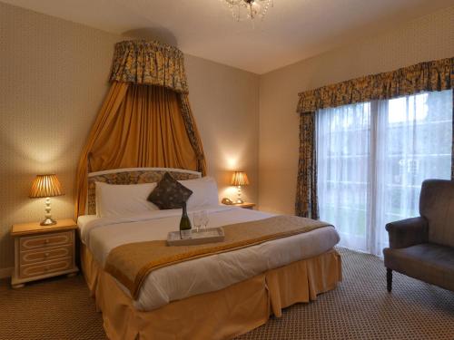 a bedroom with a large bed and a window at Marston Farm Hotel in Sutton Coldfield