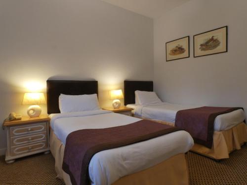 a hotel room with two beds and two lamps at Marston Farm Hotel in Sutton Coldfield