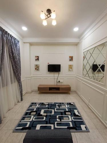 a living room with a television and a rug at NuReezal Homestay Seremban in Seremban