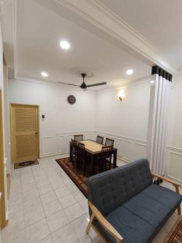 - un salon avec une table et un canapé dans l'établissement NuReezal Homestay Seremban, à Seremban