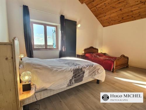 a bedroom with a large bed and a window at Les volets bleus in La Chapelle-aux-Bois