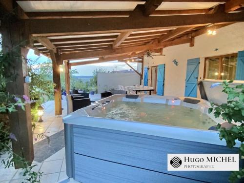 a hot tub on the patio of a house at Les volets bleus in La Chapelle-aux-Bois