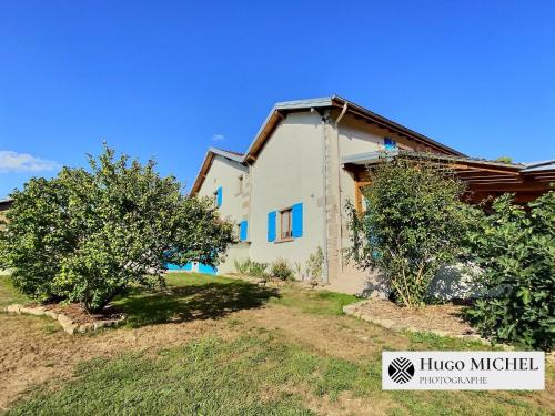 a house on a hill with two trees at Les volets bleus in La Chapelle-aux-Bois