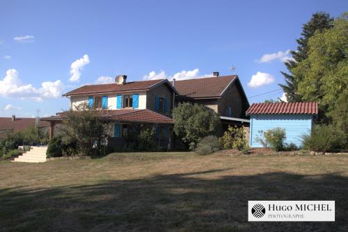 a house with a blue garage in front of it at Les volets bleus in La Chapelle-aux-Bois