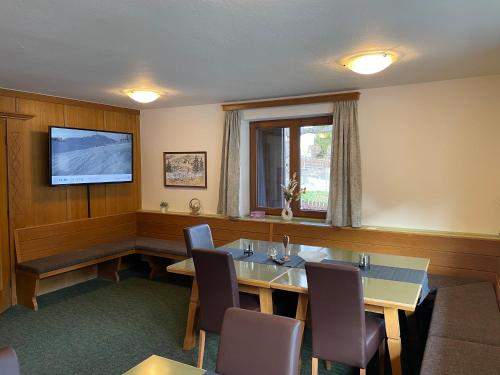 a conference room with a table and chairs and a television at Arlbergsun in Pettneu am Arlberg