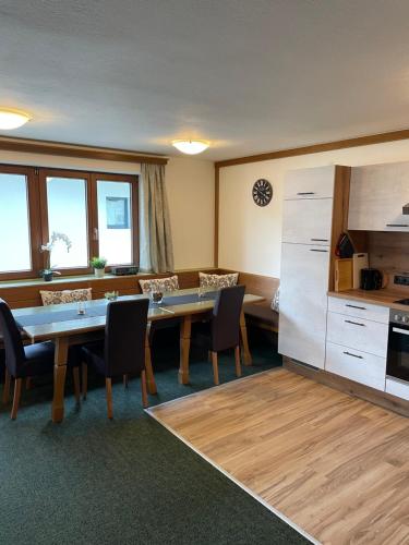 a kitchen and dining room with a table and chairs at Arlbergsun in Pettneu am Arlberg