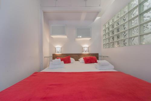 ein Schlafzimmer mit einem großen Bett mit einer roten Decke in der Unterkunft Saint Michel Quartier Latin in Paris