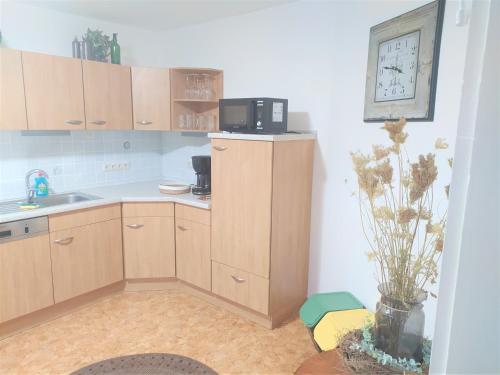a kitchen with wooden cabinets and a microwave on the wall at schöne geräumige ganze Wohnung als Unterkunft in Bergen