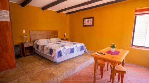 a bedroom with a bed and a wooden table at cabañas laguna de zapallar maitencillo in Zapallar