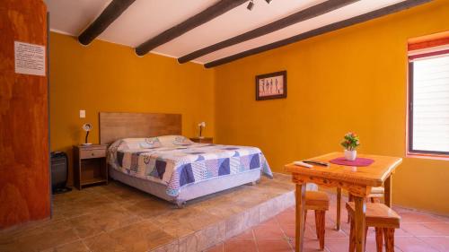 a bedroom with a bed and a wooden table at cabañas laguna de zapallar maitencillo in Zapallar