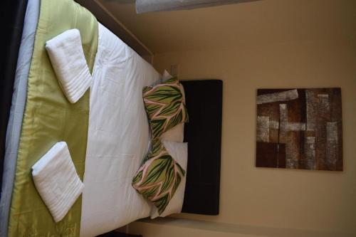 Una cama con corbata junto a dos fotos. en Braillen Suite- 2 bedroom with kitchenette and bathroom en Denbigh